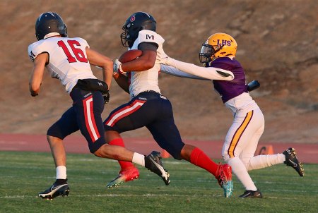 Lemoore's Aaron Villarreal looks to make a tackle in Thursday night's game against Memorial in Tiger Stadium.